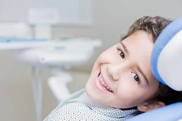 Young child smiling in dental chair at Denton Smiles Dentistry office during examination.